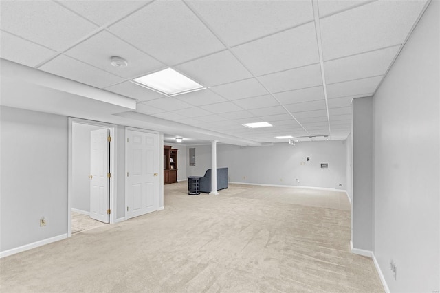 finished basement featuring carpet, electric panel, a paneled ceiling, and baseboards
