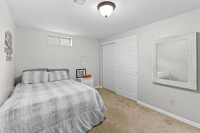 carpeted bedroom featuring a closet and baseboards