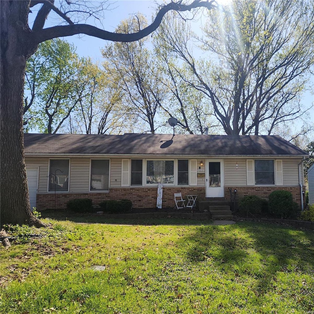 ranch-style home featuring a front lawn, entry steps, and brick siding