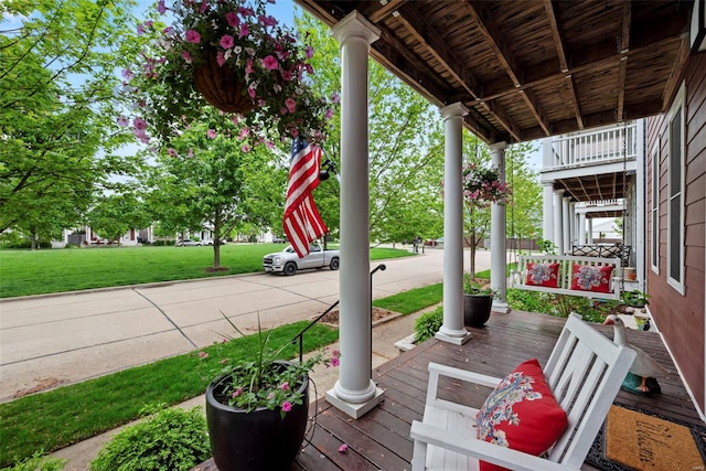 wooden deck featuring a yard and covered porch
