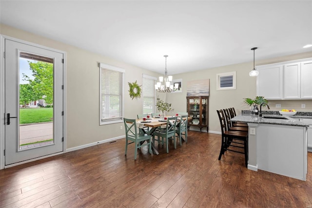 dining space with baseboards, dark wood-type flooring, and a chandelier