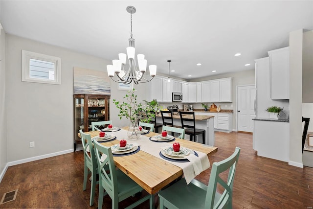 dining area featuring a chandelier, baseboards, visible vents, and dark wood-style floors