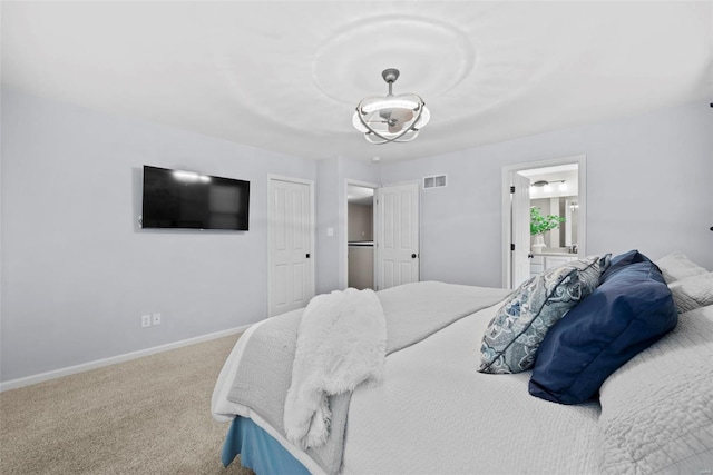 carpeted bedroom with visible vents, connected bathroom, and baseboards