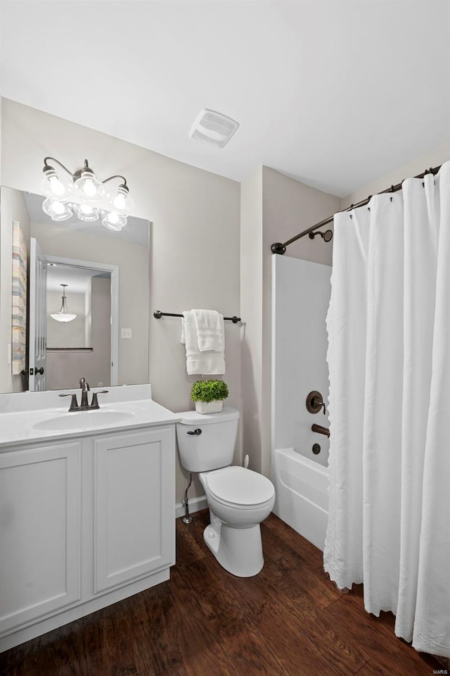 full bath featuring vanity, visible vents, shower / bath combo with shower curtain, wood finished floors, and toilet