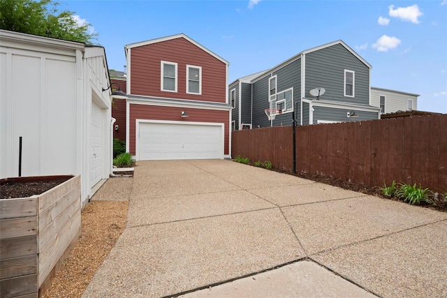 view of home's exterior featuring fence, concrete driveway, and a garage