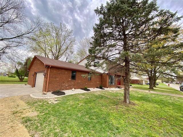 view of side of property featuring a lawn, driveway, and brick siding