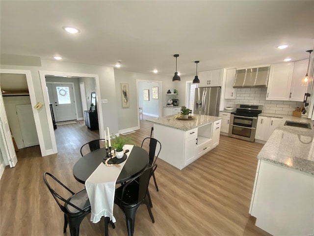 interior space featuring recessed lighting, light wood finished floors, and baseboards