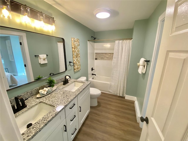 bathroom featuring toilet, wood finished floors, a sink, and shower / bath combo with shower curtain