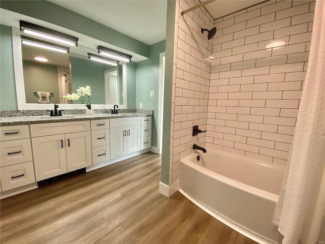 full bathroom with shower / bath combination with curtain, wood finished floors, a sink, and double vanity