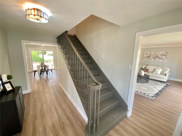 staircase with baseboards and wood finished floors