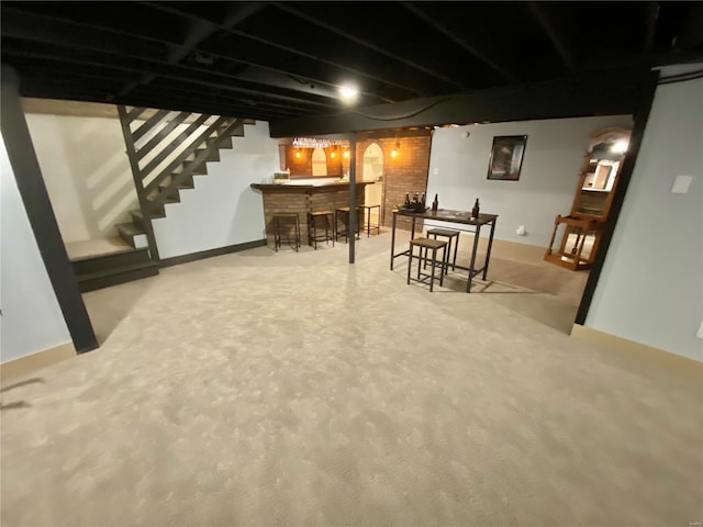 finished basement featuring indoor bar, carpet floors, and stairway