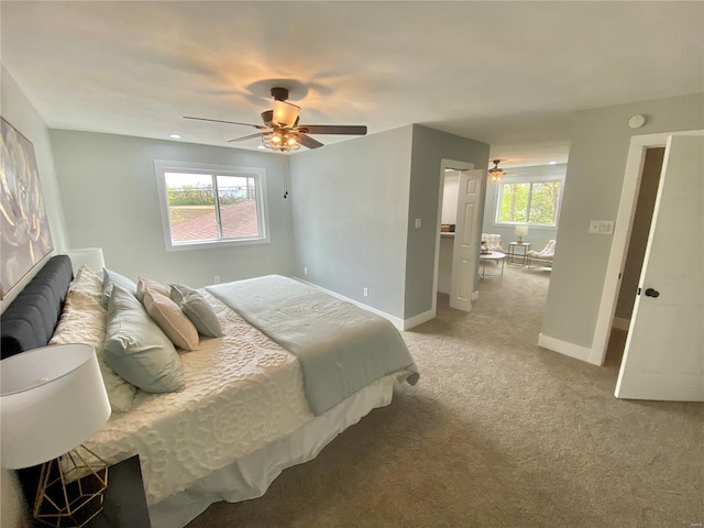 carpeted bedroom with baseboards and a ceiling fan