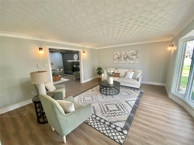 living area featuring baseboards, crown molding, and wood finished floors
