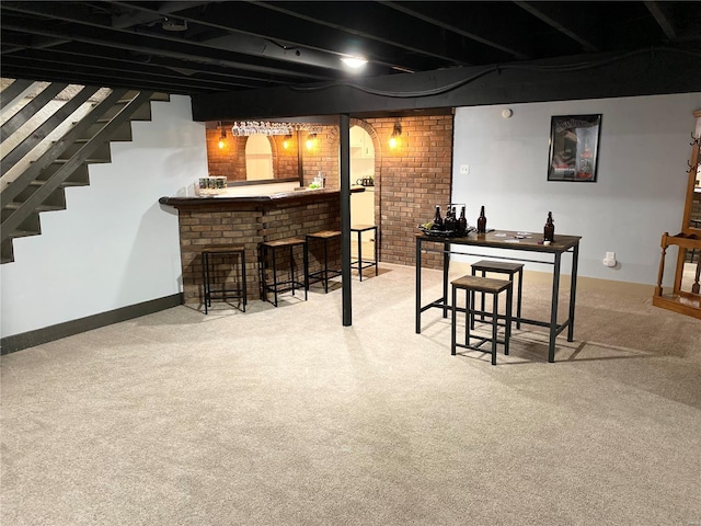 bar featuring bar, brick wall, baseboards, and carpet flooring