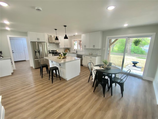 dining area with recessed lighting, light wood finished floors, and baseboards
