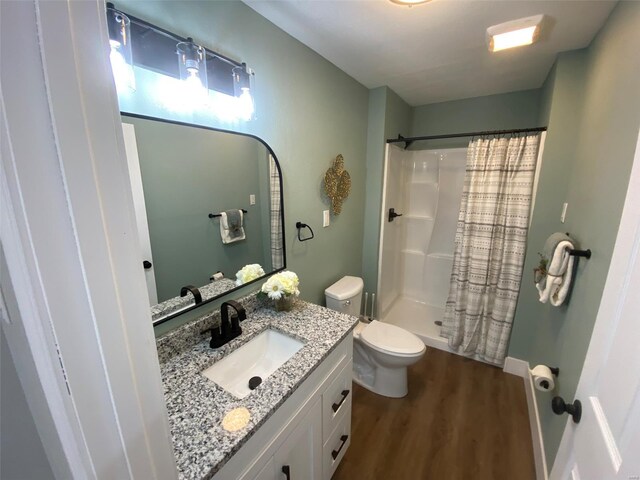 full bath with a shower with curtain, wood finished floors, vanity, and toilet