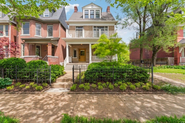 view of front of house with a chimney, covered porch, brick siding, fence, and a balcony