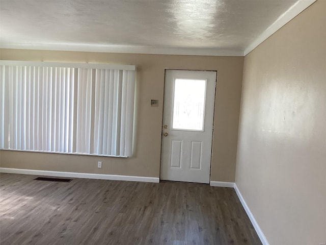 entryway with dark wood-type flooring, visible vents, and baseboards