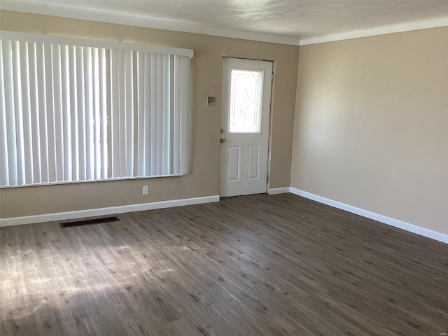 foyer featuring baseboards, visible vents, and dark wood-style floors