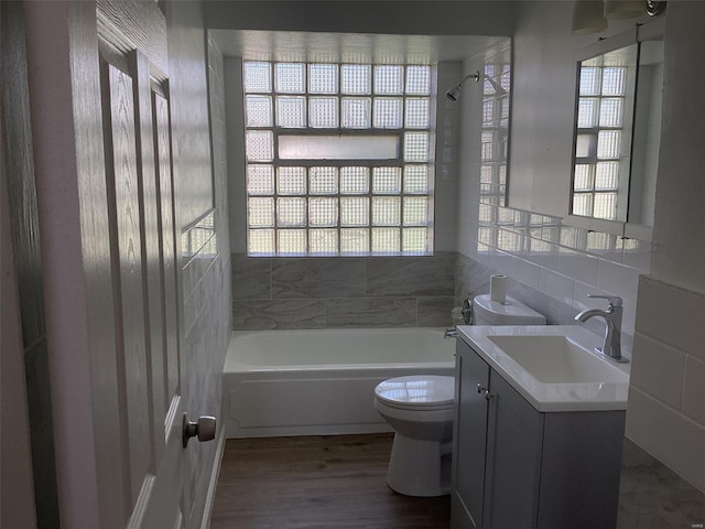 full bath featuring wood finished floors, vanity, shower / tub combination, and toilet