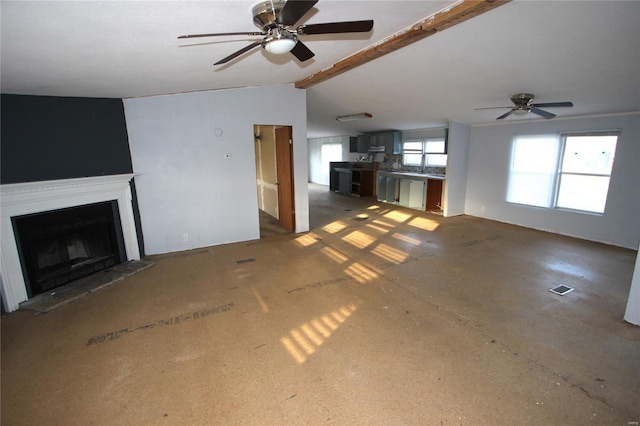 unfurnished living room with visible vents, a ceiling fan, a fireplace with raised hearth, and lofted ceiling with beams