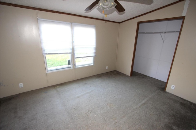 unfurnished bedroom featuring a closet, vaulted ceiling, a ceiling fan, and carpet floors