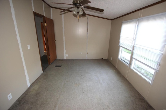 unfurnished room featuring ornamental molding, light carpet, a textured ceiling, visible vents, and ceiling fan