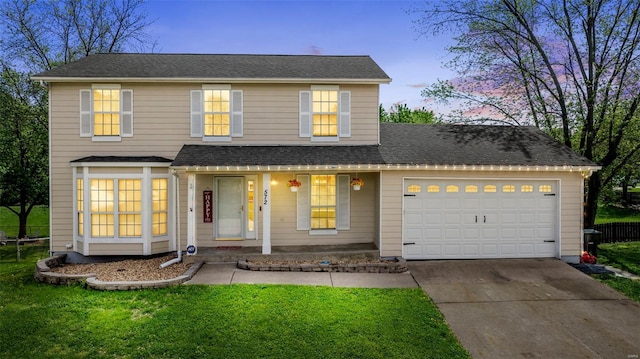 traditional home with a garage, covered porch, a front yard, and concrete driveway