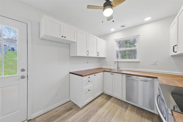kitchen featuring white cabinets, a ceiling fan, a sink, butcher block countertops, and appliances with stainless steel finishes