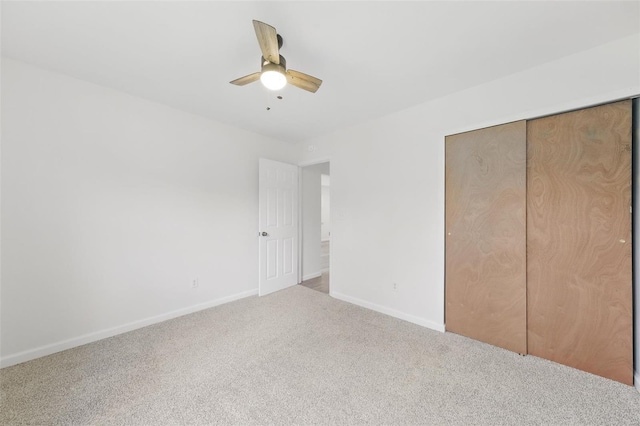 unfurnished bedroom with carpet floors, a closet, baseboards, and ceiling fan
