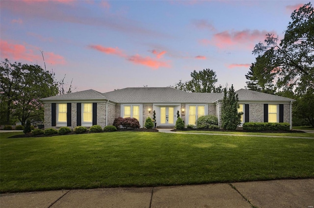 view of front facade featuring a lawn and french doors