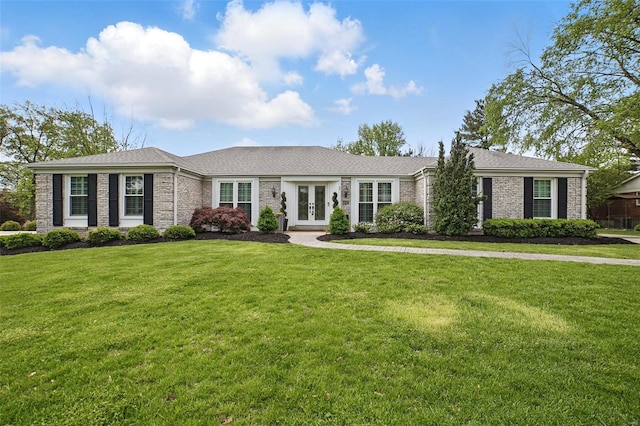 ranch-style house featuring brick siding, french doors, and a front yard