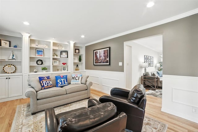 living area featuring wainscoting, ornamental molding, light wood-style floors, and recessed lighting