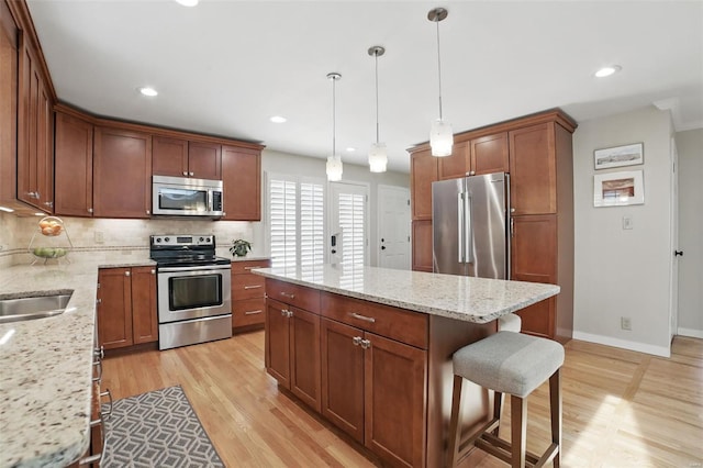 kitchen with baseboards, light wood-style floors, appliances with stainless steel finishes, and decorative backsplash