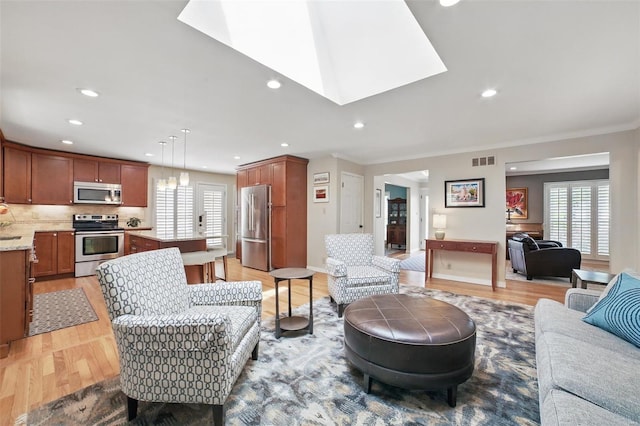 living room featuring visible vents, a healthy amount of sunlight, and light wood finished floors
