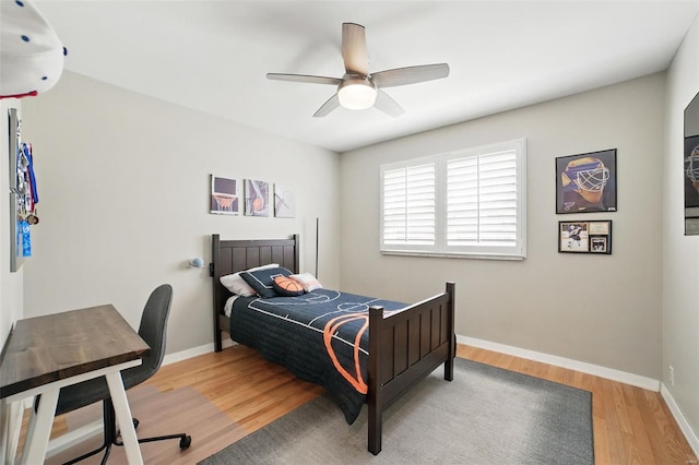 bedroom with a ceiling fan, light wood-style flooring, and baseboards