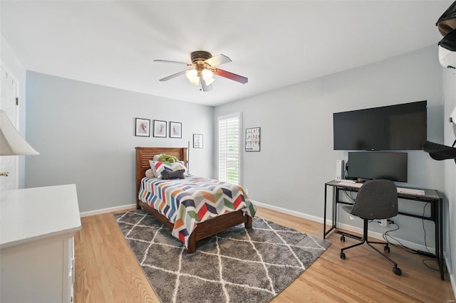 bedroom featuring ceiling fan, light wood-style flooring, and baseboards
