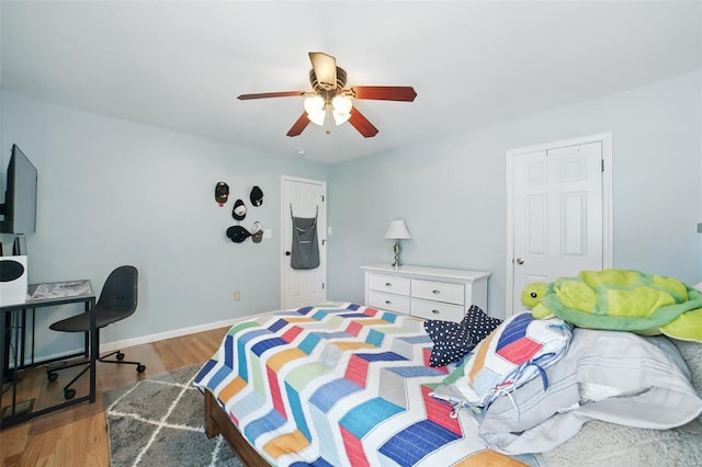 bedroom featuring baseboards, wood finished floors, and ceiling fan