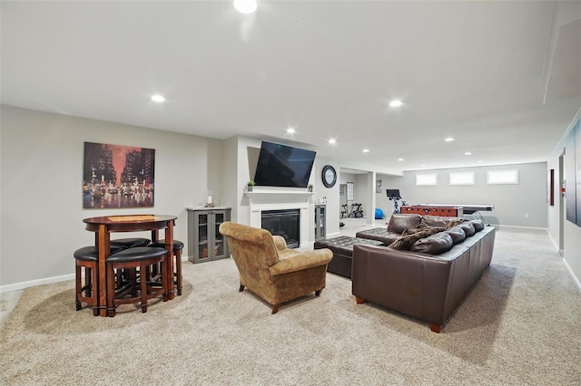 living area featuring baseboards, recessed lighting, carpet, and a glass covered fireplace
