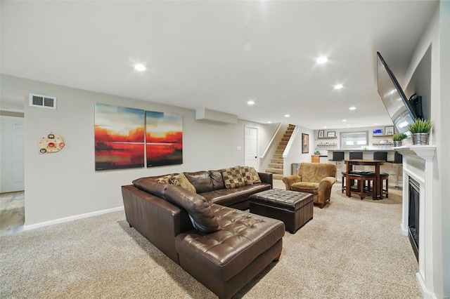 living room featuring visible vents, light carpet, stairway, and recessed lighting