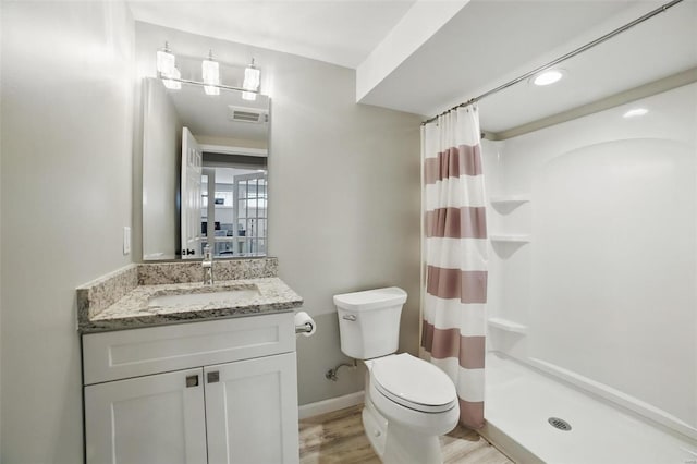 full bath featuring wood finished floors, a shower stall, toilet, vanity, and visible vents