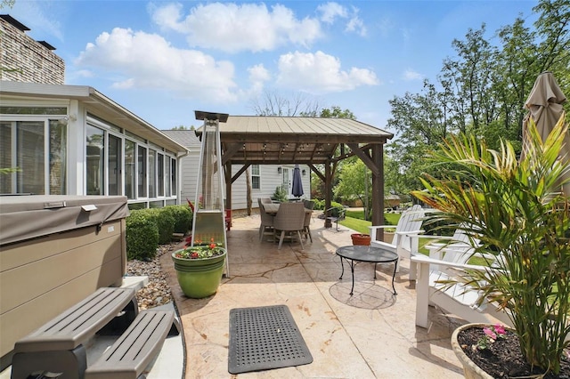 view of patio / terrace featuring a gazebo, outdoor dining space, and a sunroom