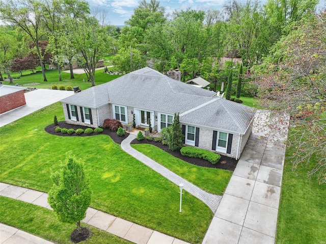 ranch-style house featuring a front yard, roof with shingles, concrete driveway, and brick siding