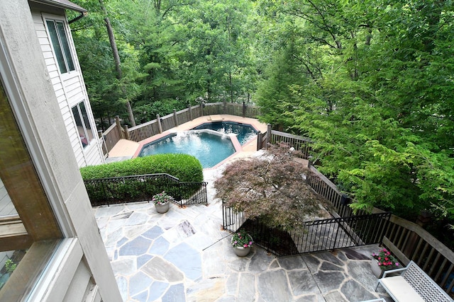 view of pool with a forest view, a patio area, and a fenced in pool