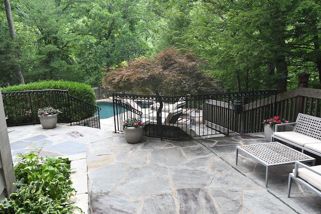view of patio / terrace with a fenced in pool and a wooded view