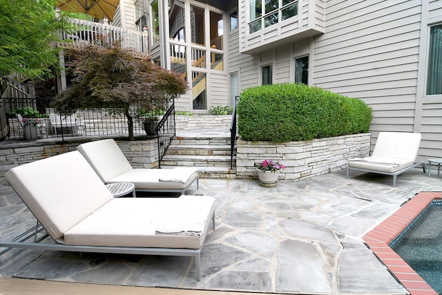 view of property's community with fence, a patio area, a pool, and stairs