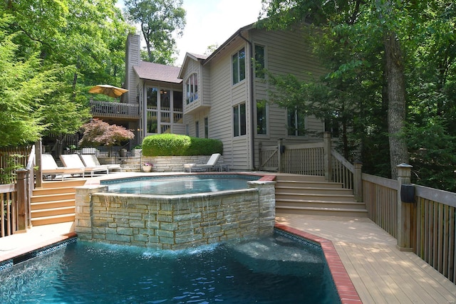 view of pool with a wooden deck, a fenced in pool, and an outdoor hot tub