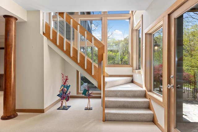 stairway with baseboards and carpet flooring
