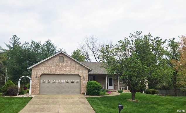 ranch-style home featuring brick siding, an attached garage, a front yard, and concrete driveway