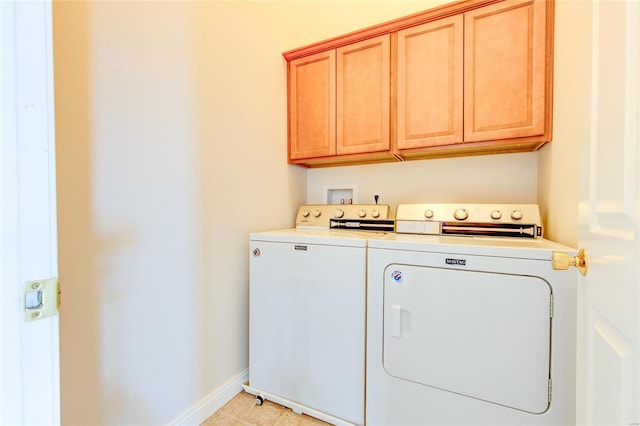 laundry room with washing machine and dryer, baseboards, and cabinet space